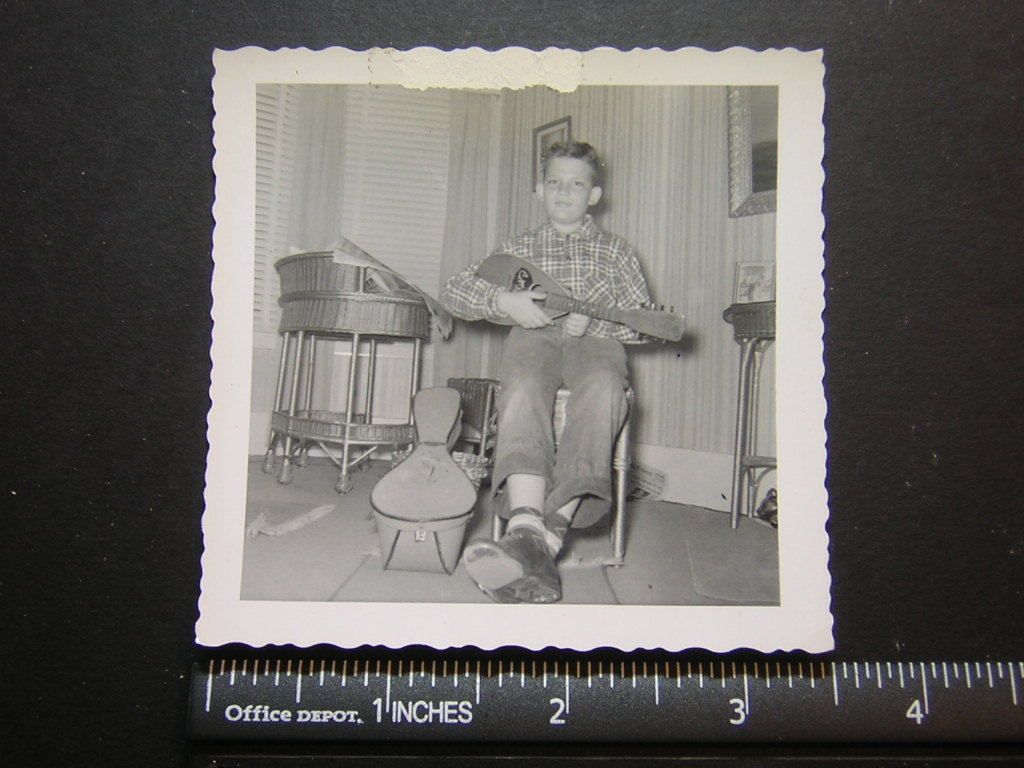 Photo 03023 tween boy sits in chair & plays mini guitar